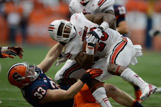 Syracuse linebacker Dan Vaughan pulls down Louisville running back Corvin Lamb.