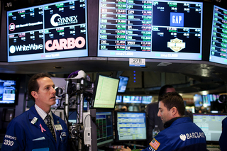 Workers at the NYSE are visited by representatives from the Syracuse and West Virginia football teams.