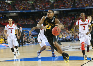 Carl Hall #22 of the Wichita State Shockers drives to the basket against Peyton Sive #3 and Russ Smith #2 of the Louisville Cardinals.