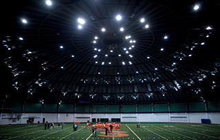 Syracuse players walk out to the middle of the field. 