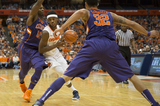 Fair drives the lane against two Clemson defenders. 