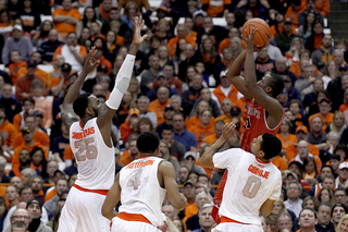 Christmas goes for a block on a shot by SJU guard Phil Greene IV while Ron Patterson and Michael Gbinije defend as well. 