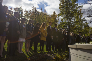 Remembrance Scholars stand around the Remembrance Wall during the Rose Laying Ceremony Friday afternoon.