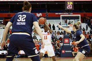 Gabrielle Cooper holds the ball over her head on the wing.