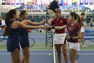 Sofya Golubovskaya and Sonya Treshcheva meet their opponent at the net.