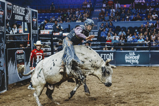 Dakota Louis tries to remain balanced as his bull shoots out of the bucking chute.