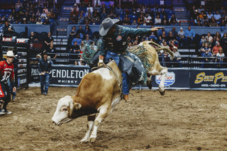 Lindomar Lino holds a steady grip on his bull rope as his bull bucks.